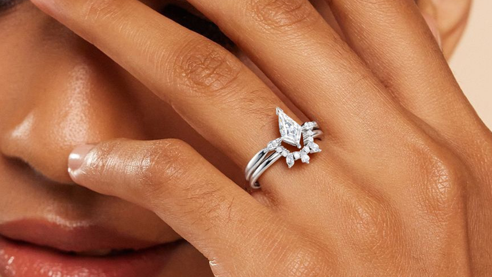 A woman wearing a BRILLIANT CARATS ring on her ring finger.