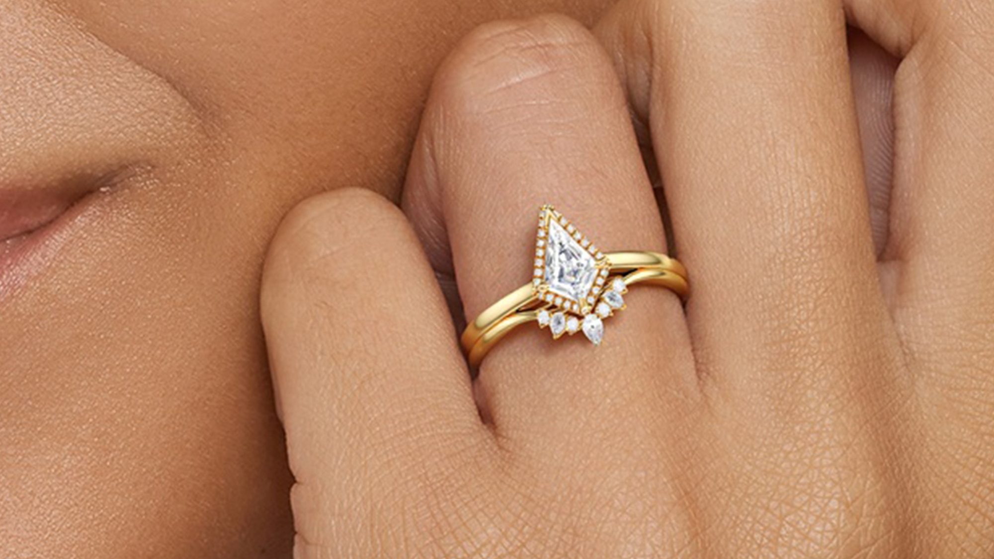 A woman wearing a BRILLIANT CARATS ring on her ring finger.