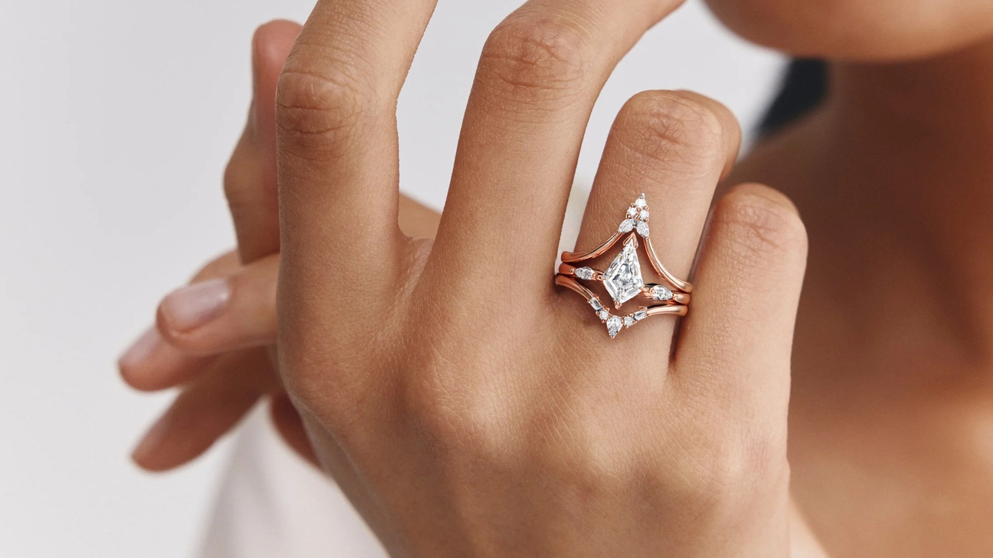 A woman wearing a BRILLIANT CARATS ring on her ring finger.